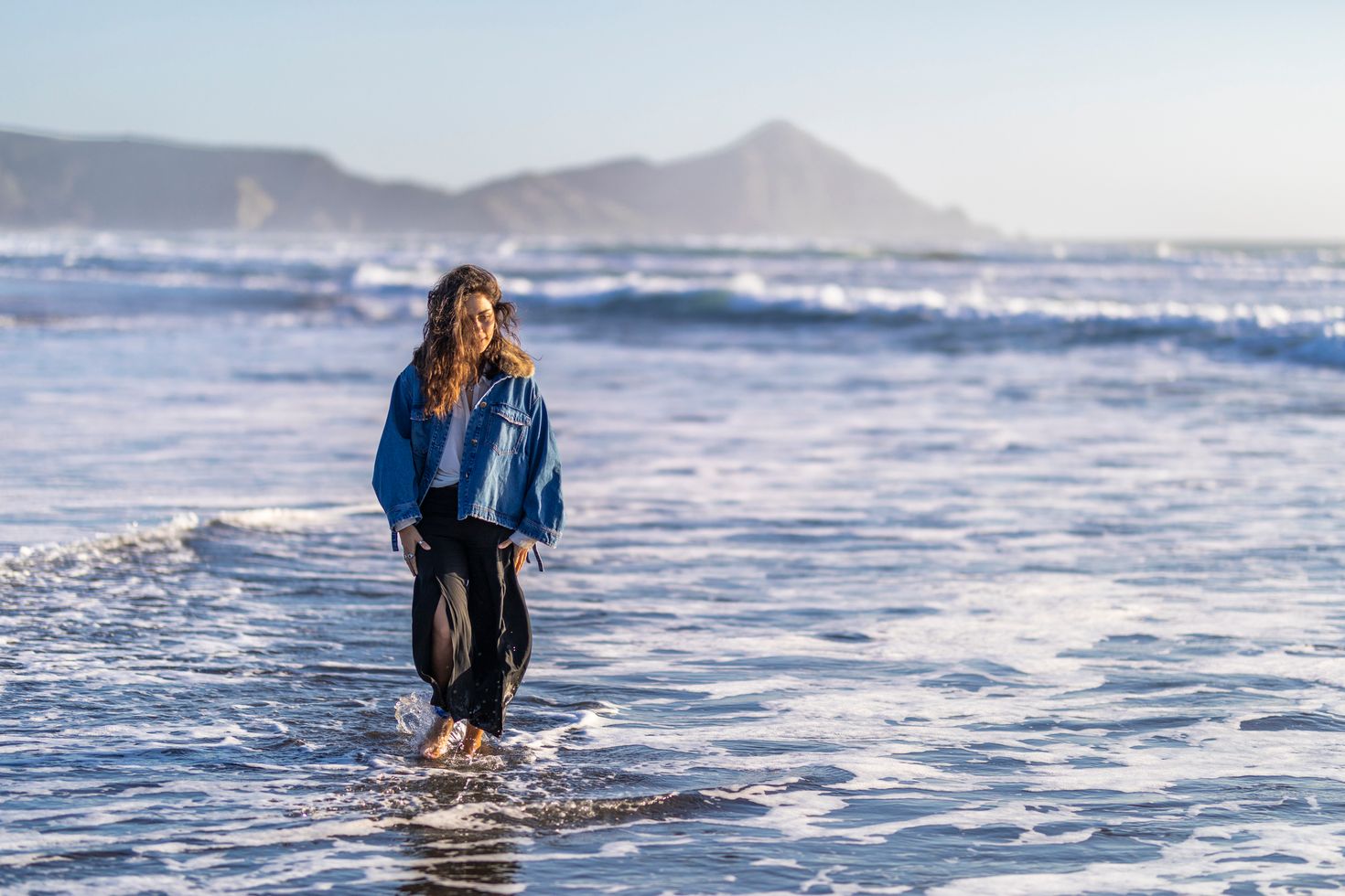 A tourist girl enjoying the water waves at Topocalma beach in Chile.