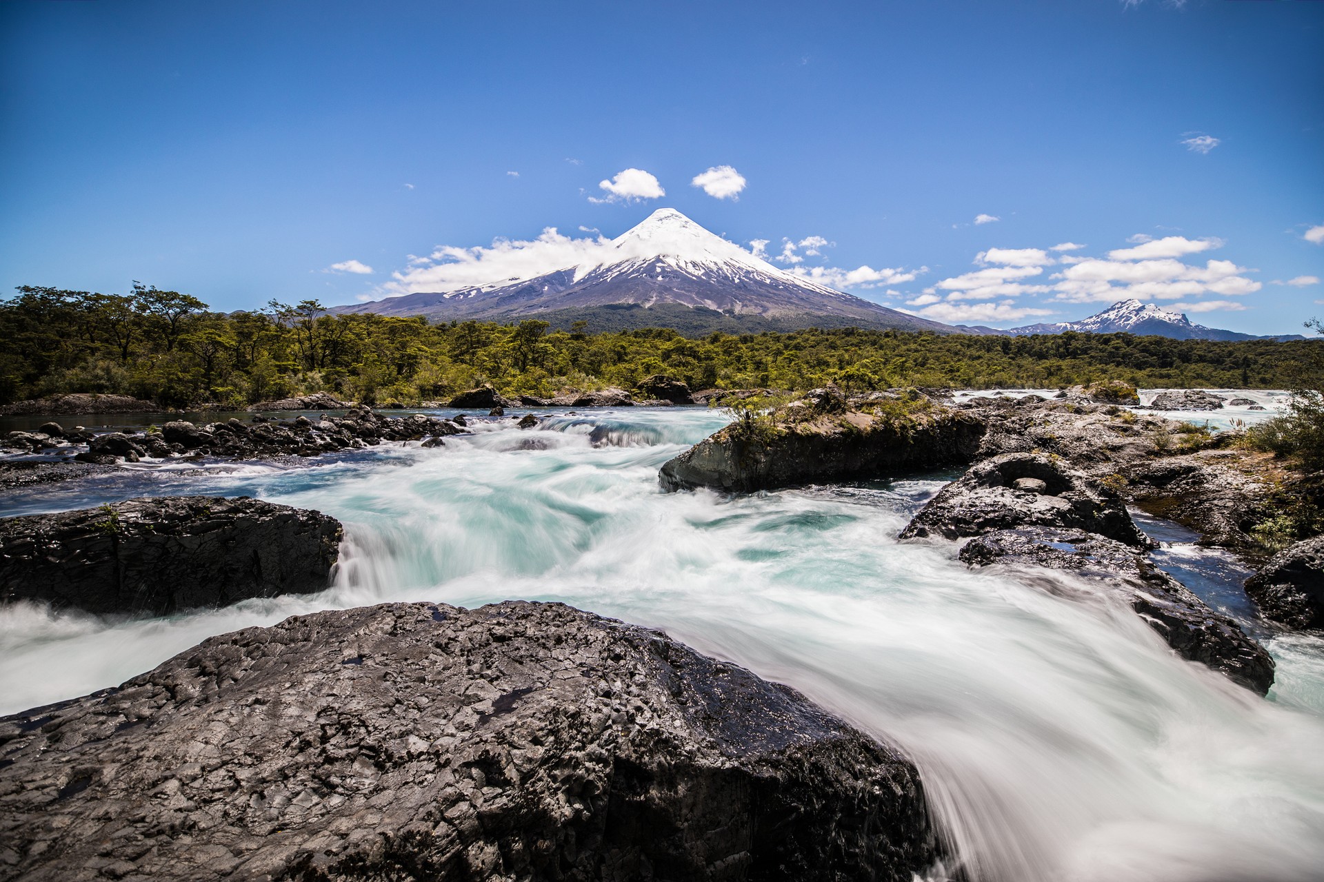Waterfall in the foreground of the Osorno Volcano within the Lake District in Chile in March.