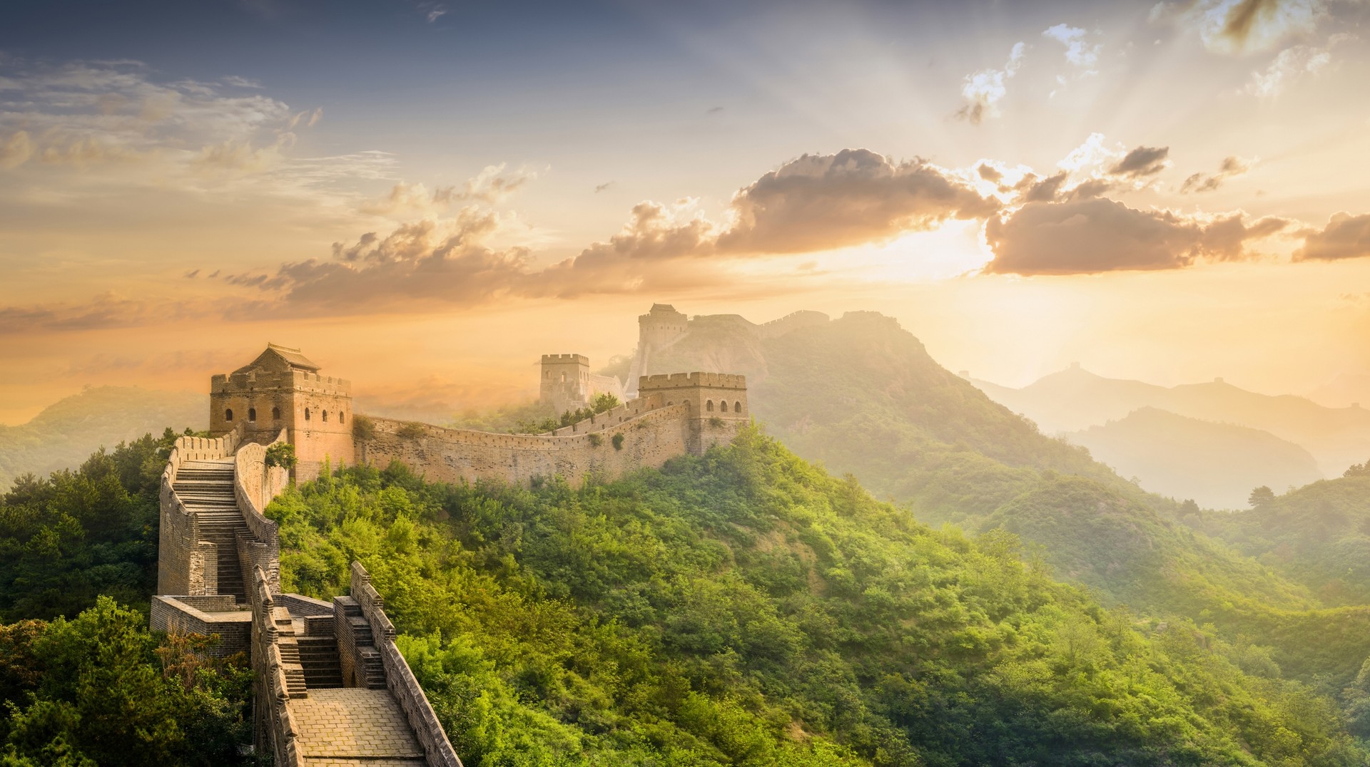 The Great Wall in China in June during sunset, surrounded by greenery.