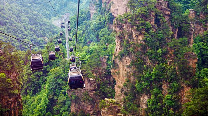 Ride on cable cars going up and down the Zhangjiajie National Forest Park while spending one week in China.