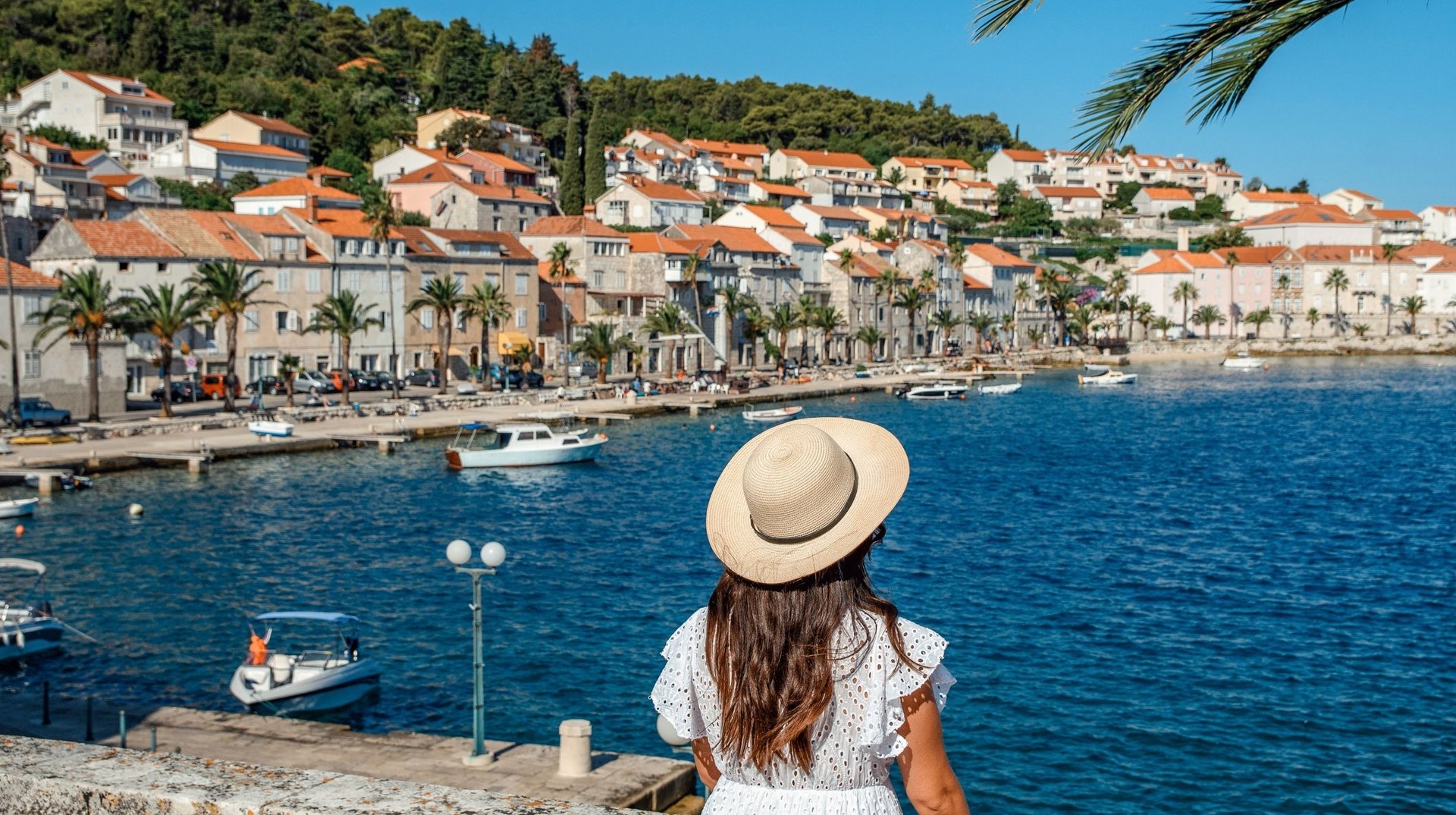 Explore Korčula Town during your 10 days in Croatia and wander through its charming medieval streets, vibrant history, and stunning coastal views. A tourist girl enjoying the view of Korcula Town on a sunny day during her 10 days in Croatia.