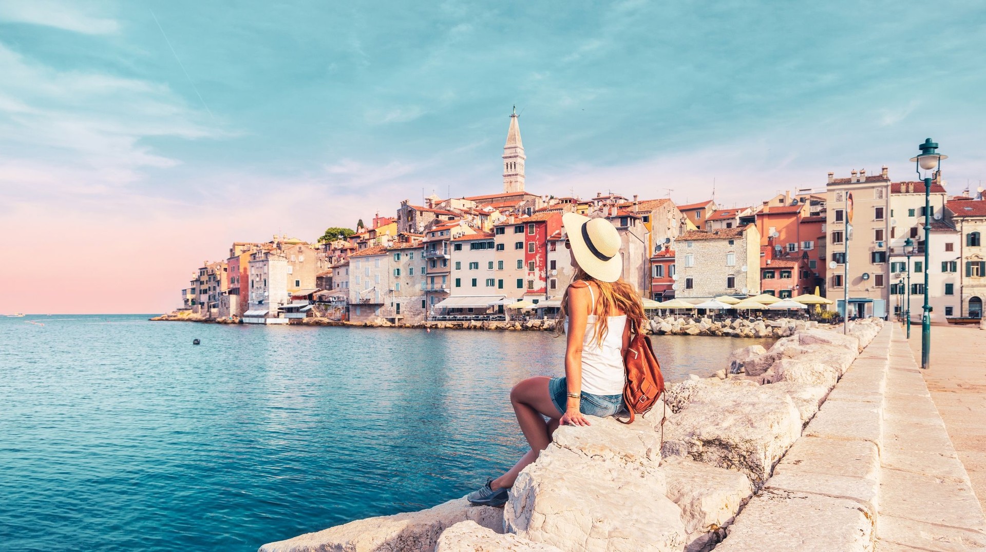 Savor two weeks of pure bliss in Croatia, where the beaches and crystal-clear sea offer the perfect coastal escape. A girl relaxing and enjoying the view of sea during her 2 weeks in Croatia.