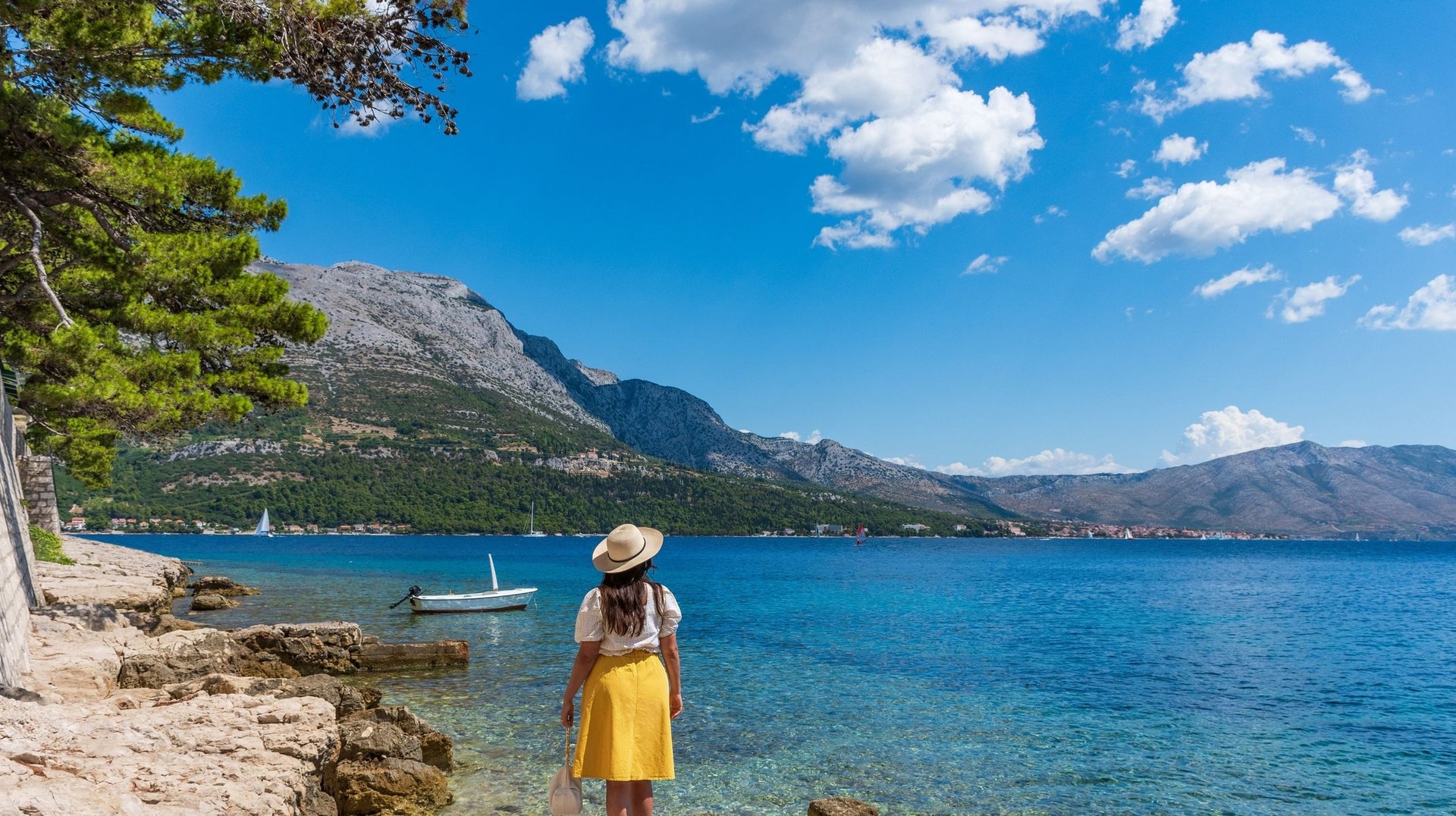 Discover the charm of Korčula as you explore its ancient streets and stunning coastline during your 8 days in Croatia. A tourist girl admiring the beauty of Korcula during her 8 days in Croatia trip.
