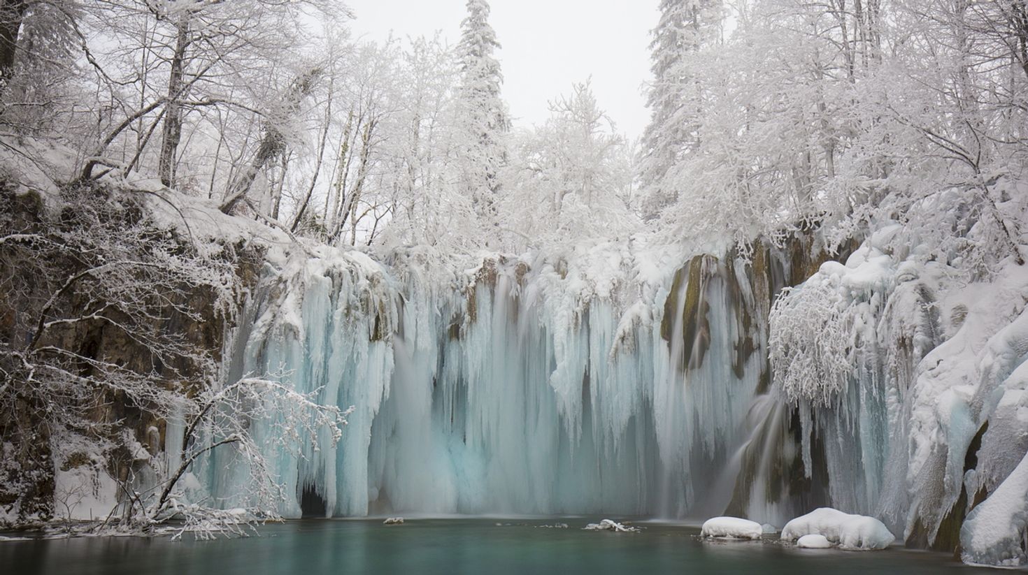 Winter landscape with white snowy trees and frozen waterfalls