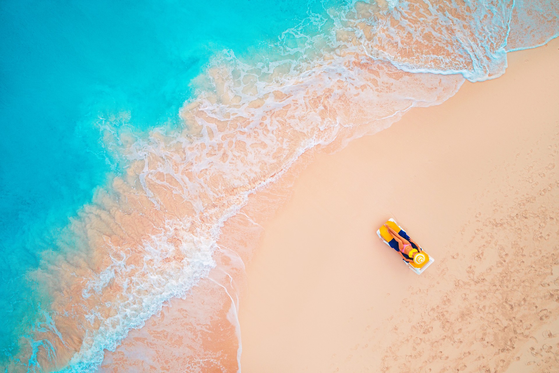 Aerial view of a woman lying on the beach and sunbathing in Cuba in June.