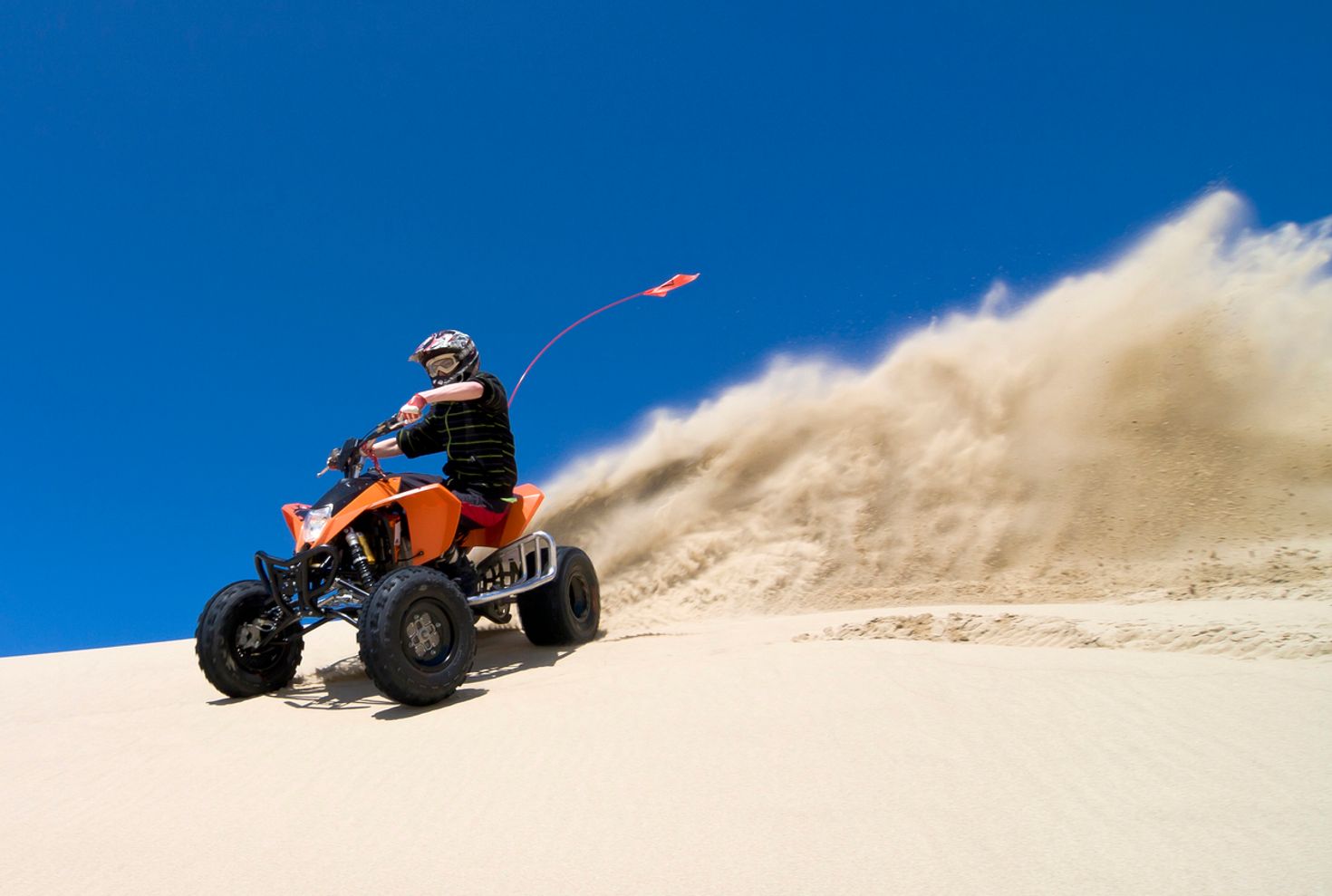 Ride through the sand on a quad bike in a desert safari in Dubai