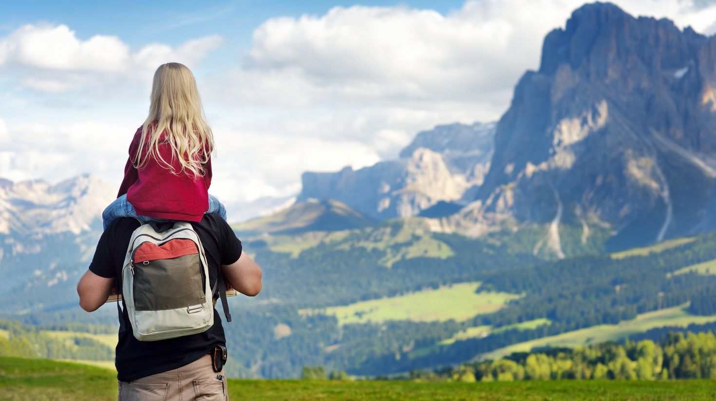 Father and his daughter admiring a view of Seiser Alm in the Dolomites.