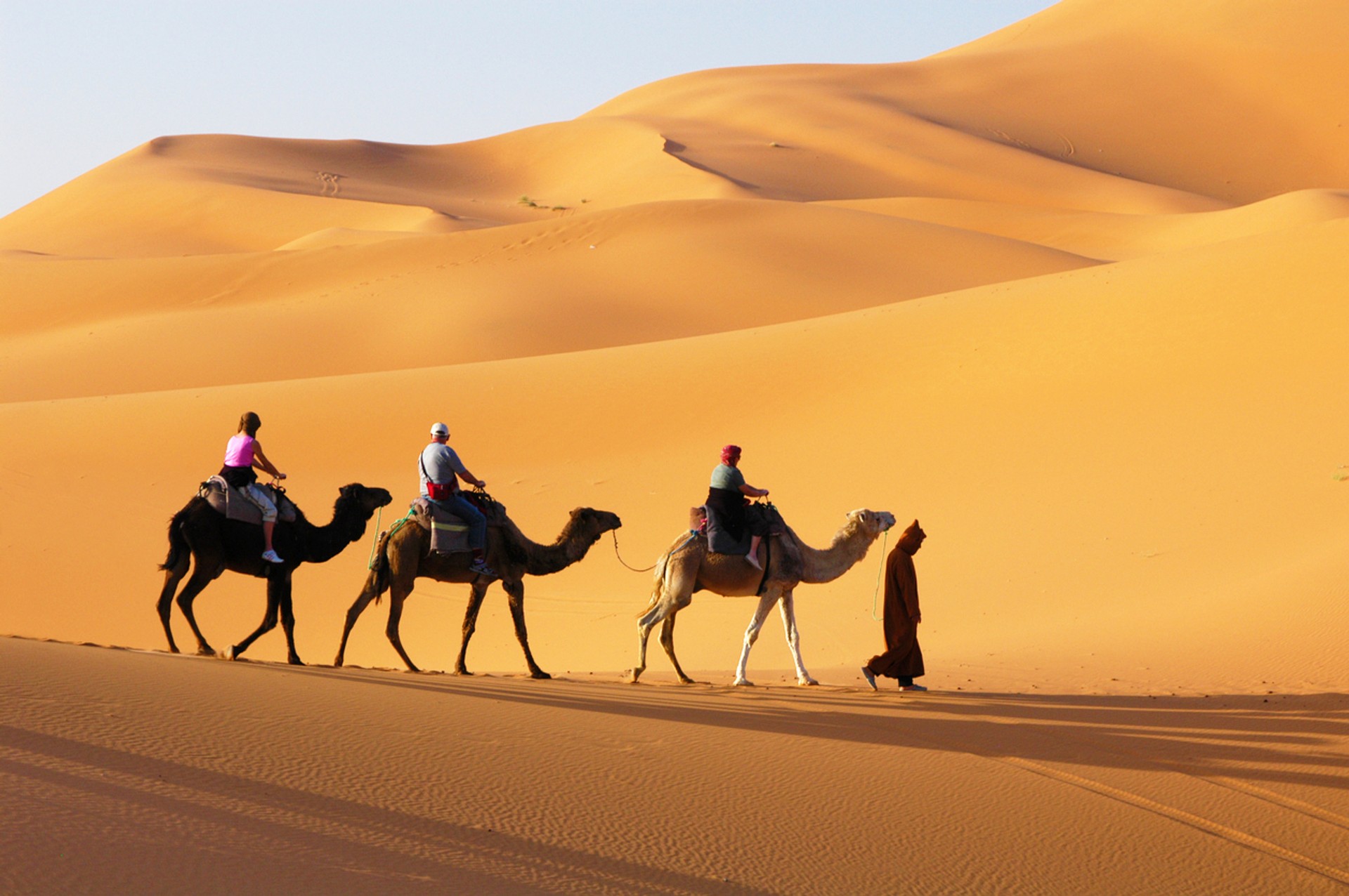 When spending 6 days in Dubai, be sure to enjoy an exhilarating desert safari riding camels to the sand dunes. Tourists riding camels on their desert safari as a part of spending 6 days in Dubai.