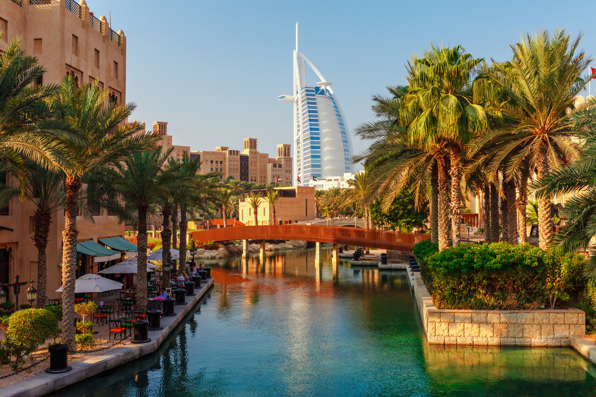 Shaped like the sail of an Arabian dhow, Dubai's iconic Burj Al Arab is one of the tallest hotels in the world. View of Burj Al Arab seen amidst palm trees in Dubai during 8-day itinerary