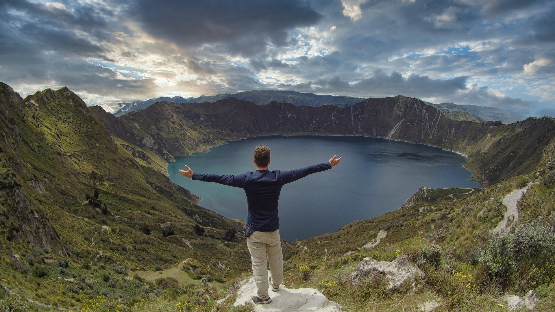 A hiker tourist with open arms looking at Quilotoa during his 2 weeks in Ecuador.