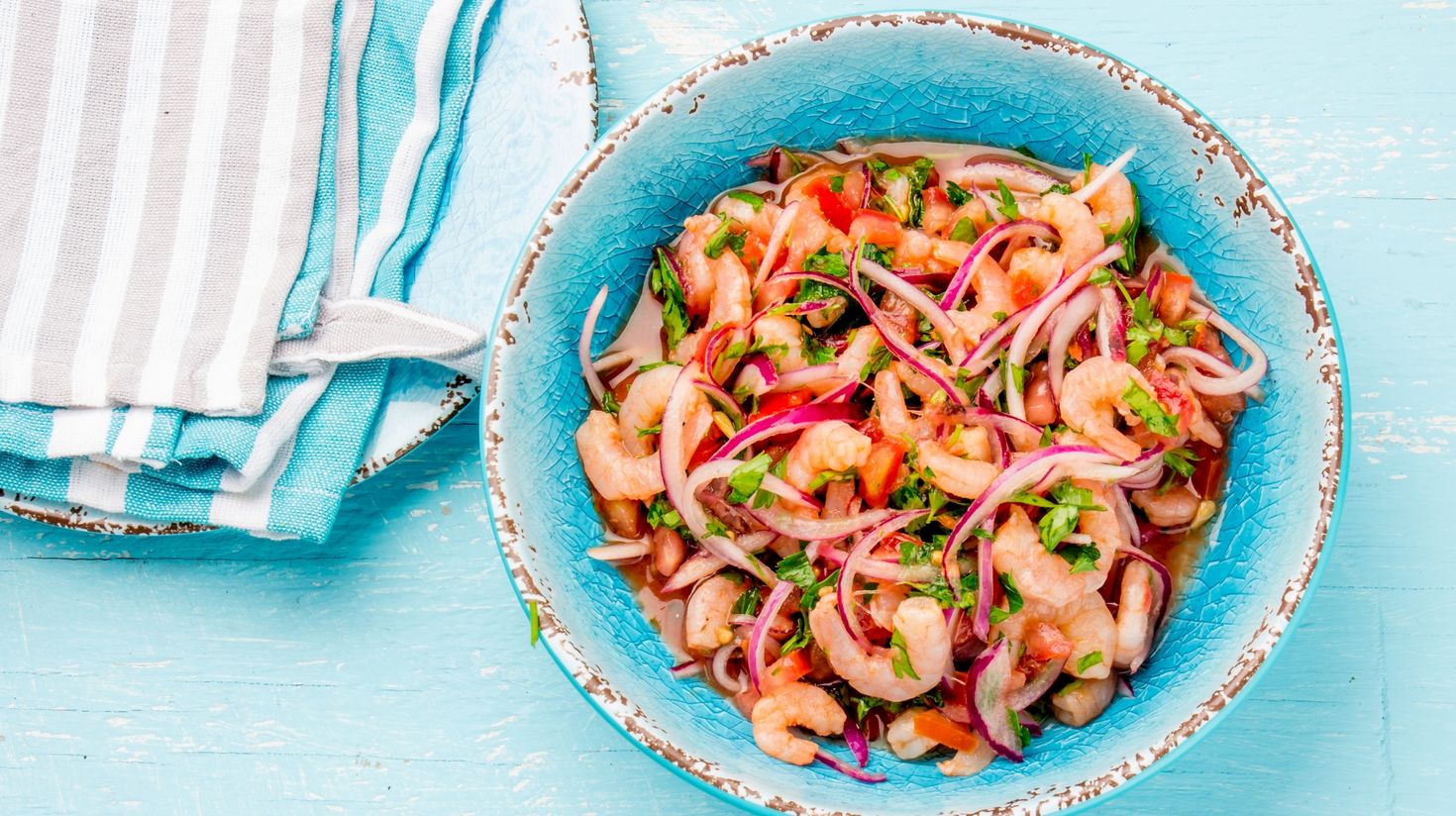 Ecuadorian shrimps are served with tomatoes with a blue setting.