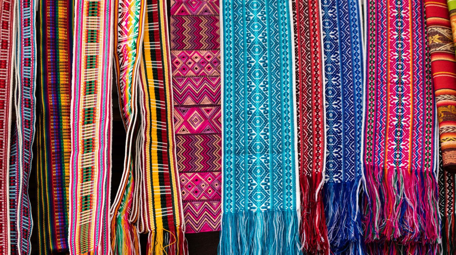 Find colorful fabrics in markets of Otavalo.
