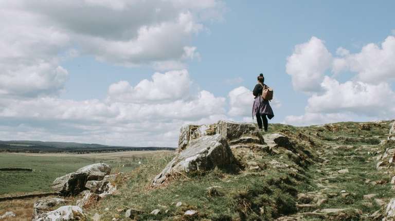Girl hiking in Northumberland National Park during a stay of England in 4 days.