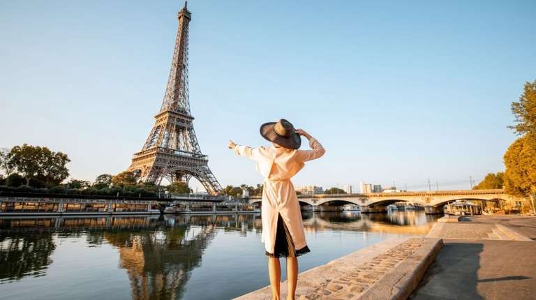 A tourist girl pointing at Eiffel Tower during her 11 days in Europe trip.