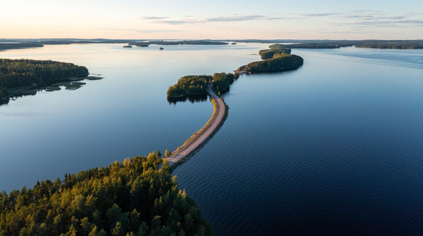 Pulkkilanharju ridge road and calm Paijanne lake in summer in Finland.