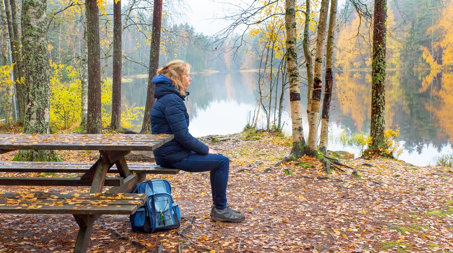 A woman sitting on a bench in Finland in October.