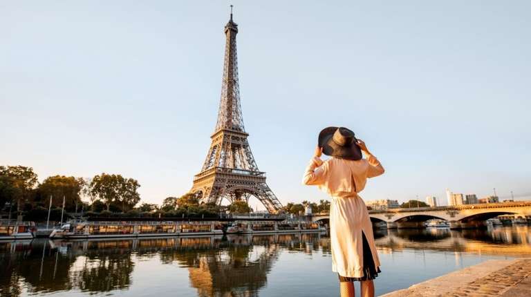 A woman enjoying the beauty of Eiffel Tower during 11 days in France tour.
