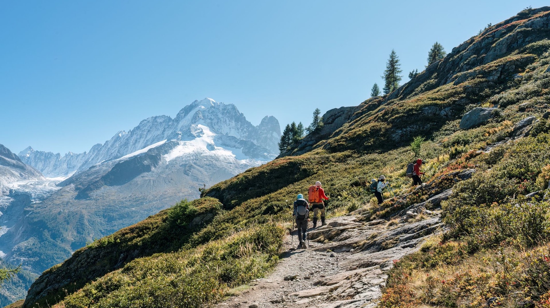 The French Alps feature the tallest peaks in France, premier ski resorts, and the most popular hiking and walking trails. Travelers to France hiking in the French Alps on a sunny day