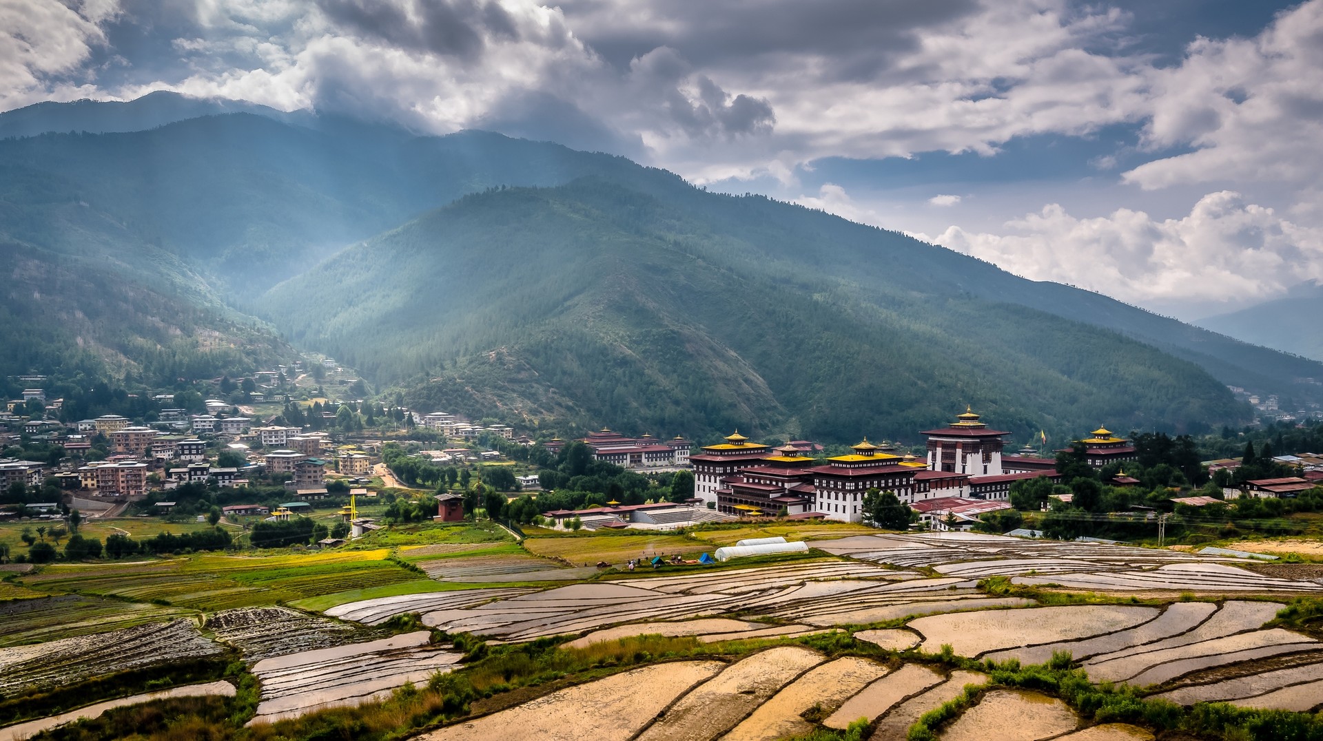 Panoramic view of Thimphu Dzong in Bhutan with paddy fields are must see during 6-day itinerary