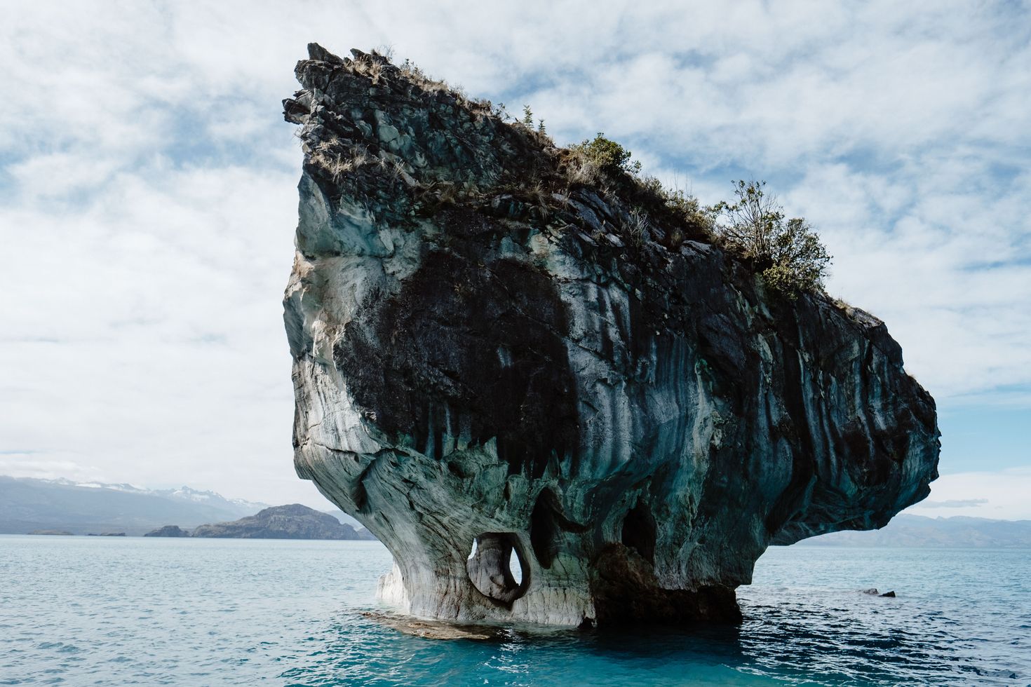 A huge rock island in the middle of a lake