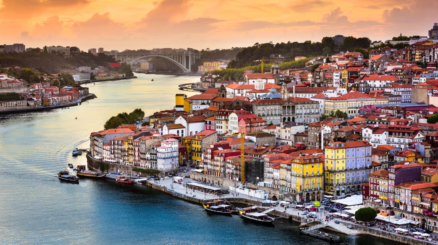 A colorful European town with a river running next to it with boats