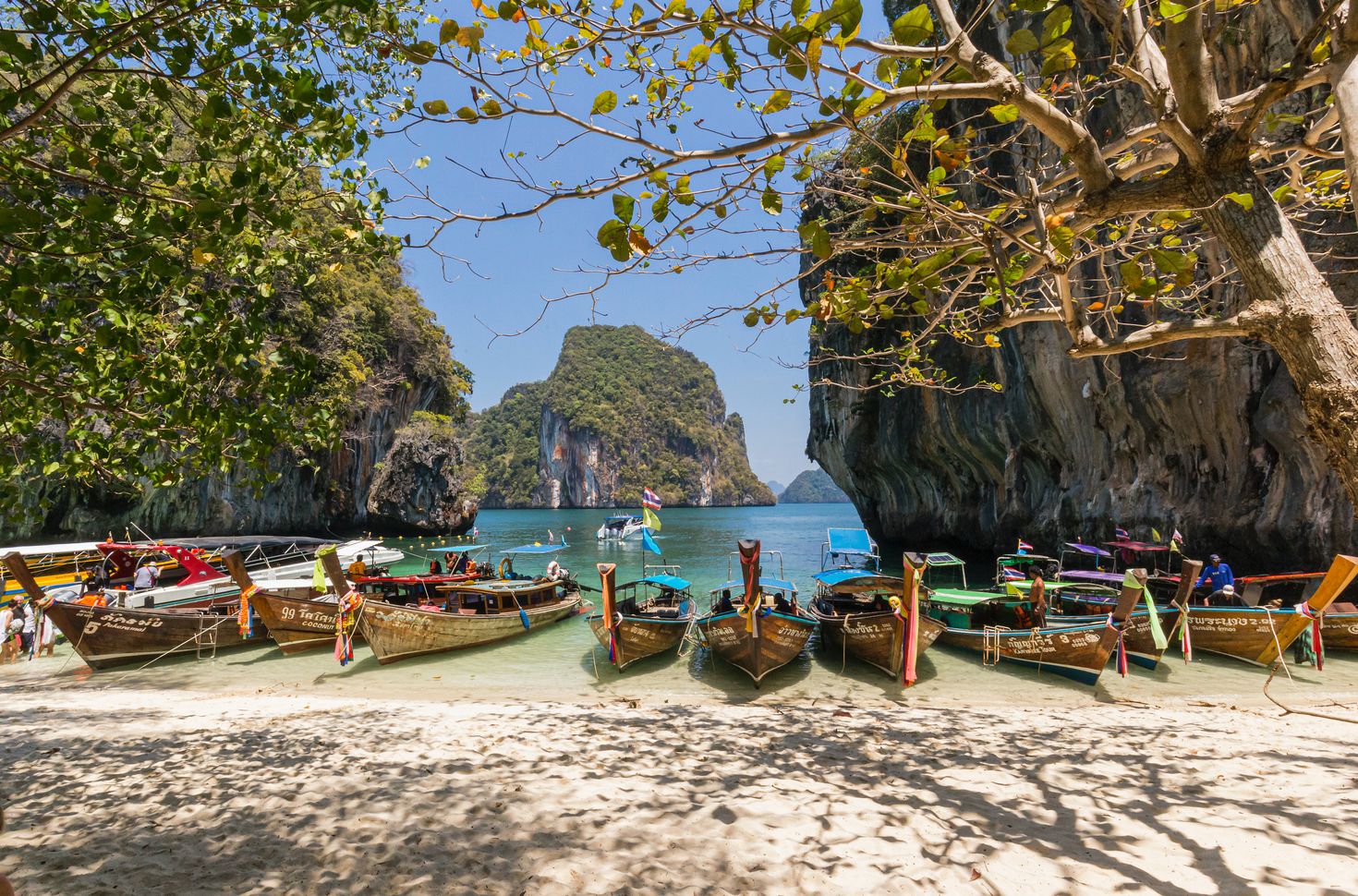 Thailand has the most beautiful islands with boats and greenery.