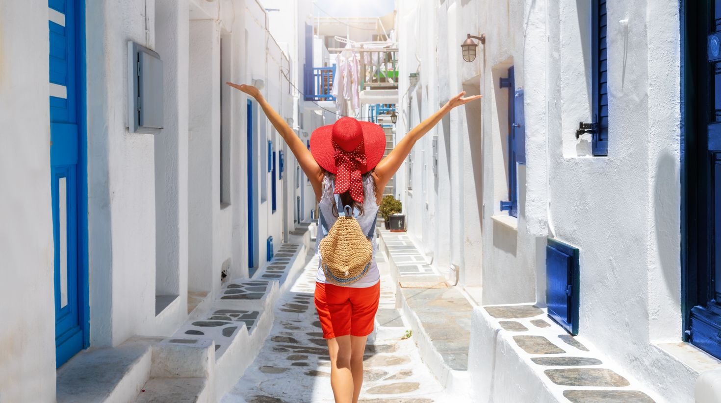 Woman walks through the white and blue streets of the Cyclades islands of G