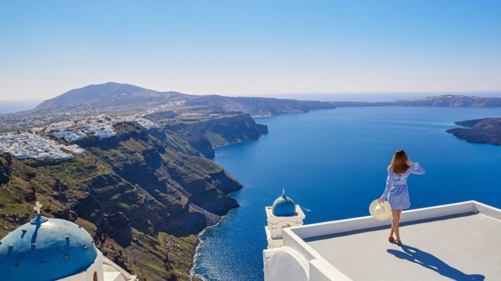 A young girl looks at marine landscapes in Santorini in Greece in October.