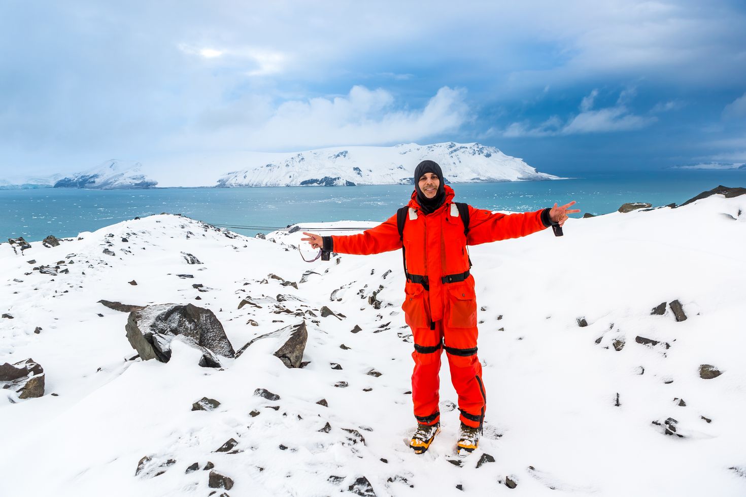 A hiker walks through ice and snow while hiking in Antarctica.