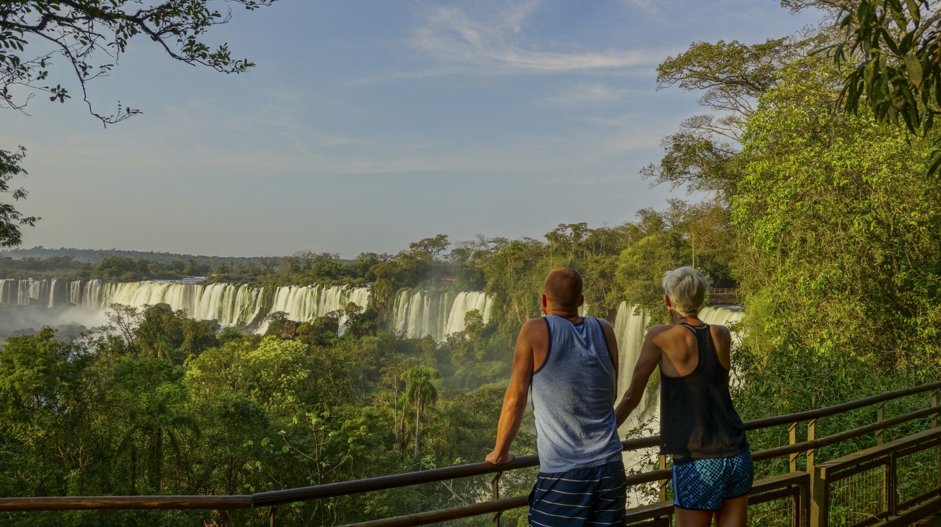 Enjoy the majestic Iguazu falls while you are in honeymoon in Argentina. A couple enjoying the beauty of Iguazu falls, Honeymoon in Argentina.