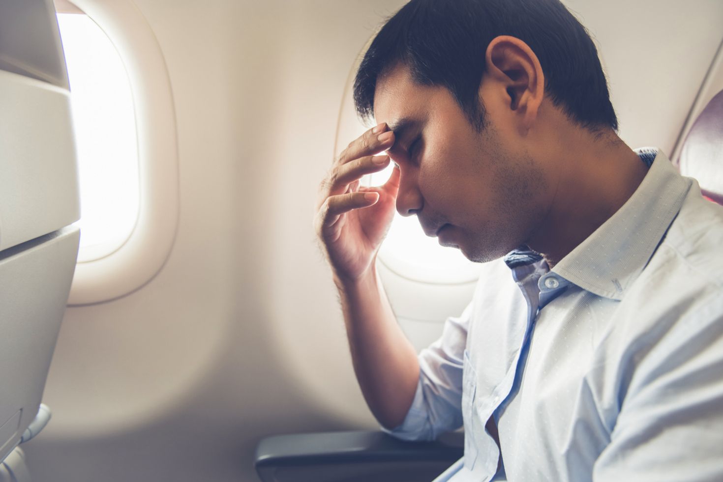 Man trying to sleep on a plane