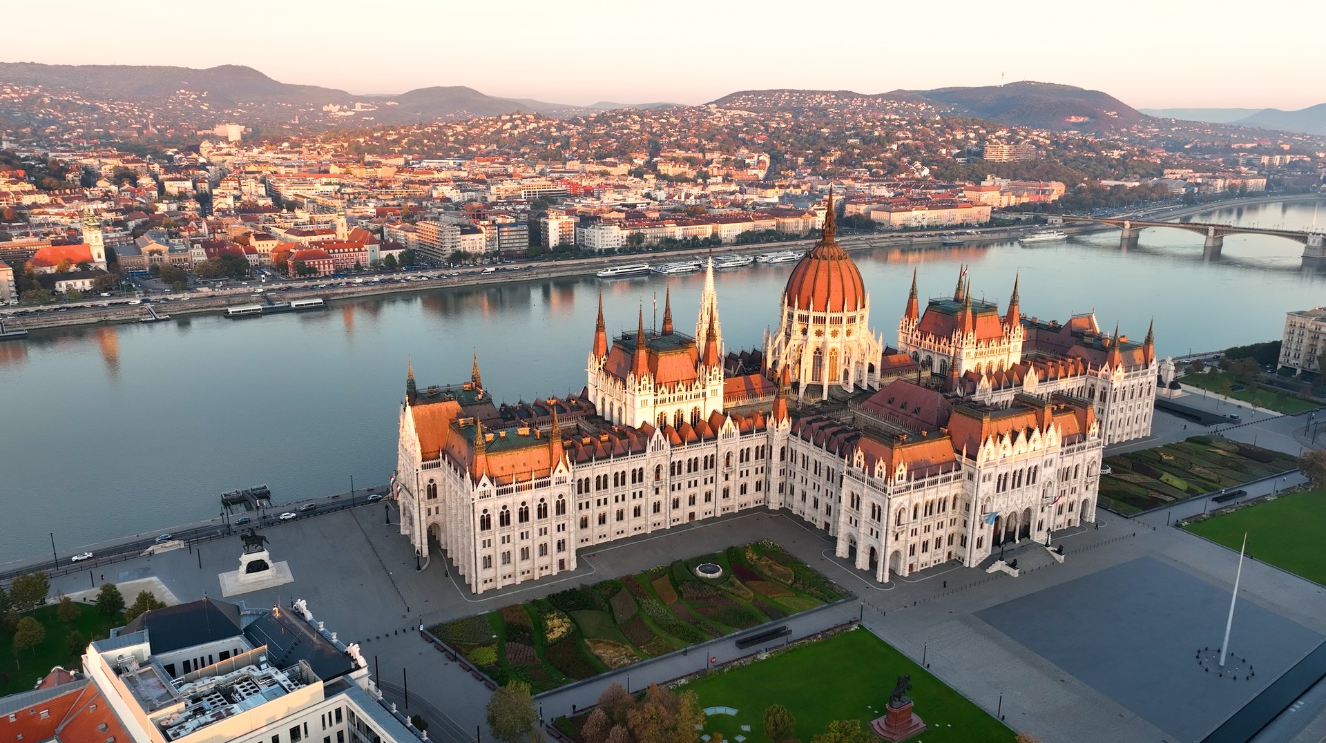 Traveling to Hungary in April means you will enjoy the spring weather with fewer tourists around. Aerial view of the Parliament building during sunset in Hungary in April.