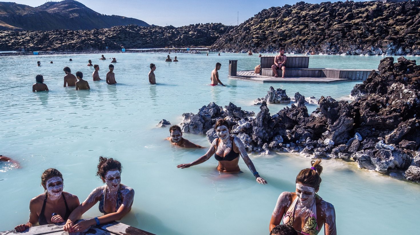 Tourists relaxing in the Blue Lagoon with silica on their faces.