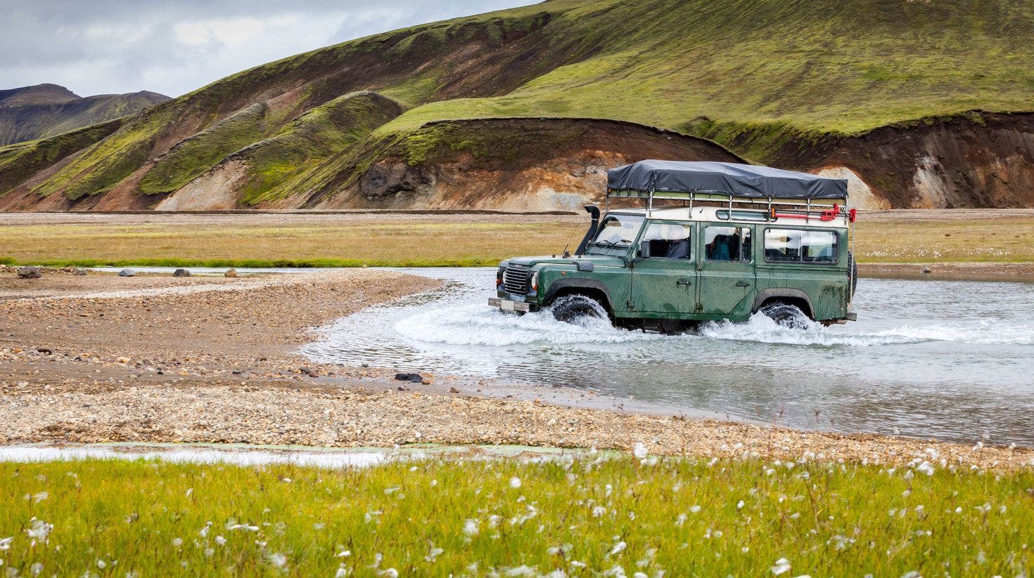 4x4 super jeep crossing a river in Landmannalaugar during July in Iceland.