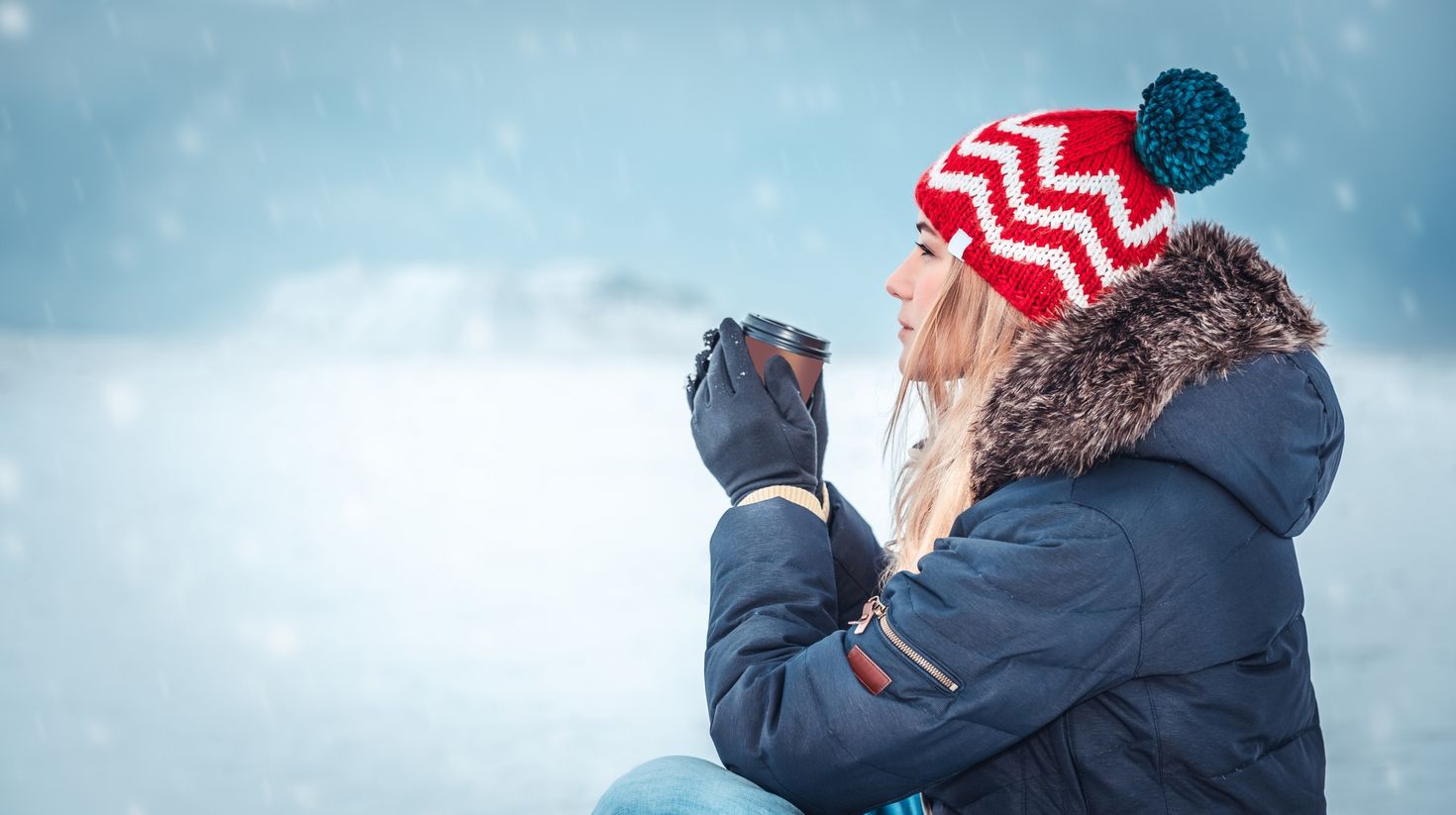 Nice girl sitting outside on a snowy winter day in Iceland