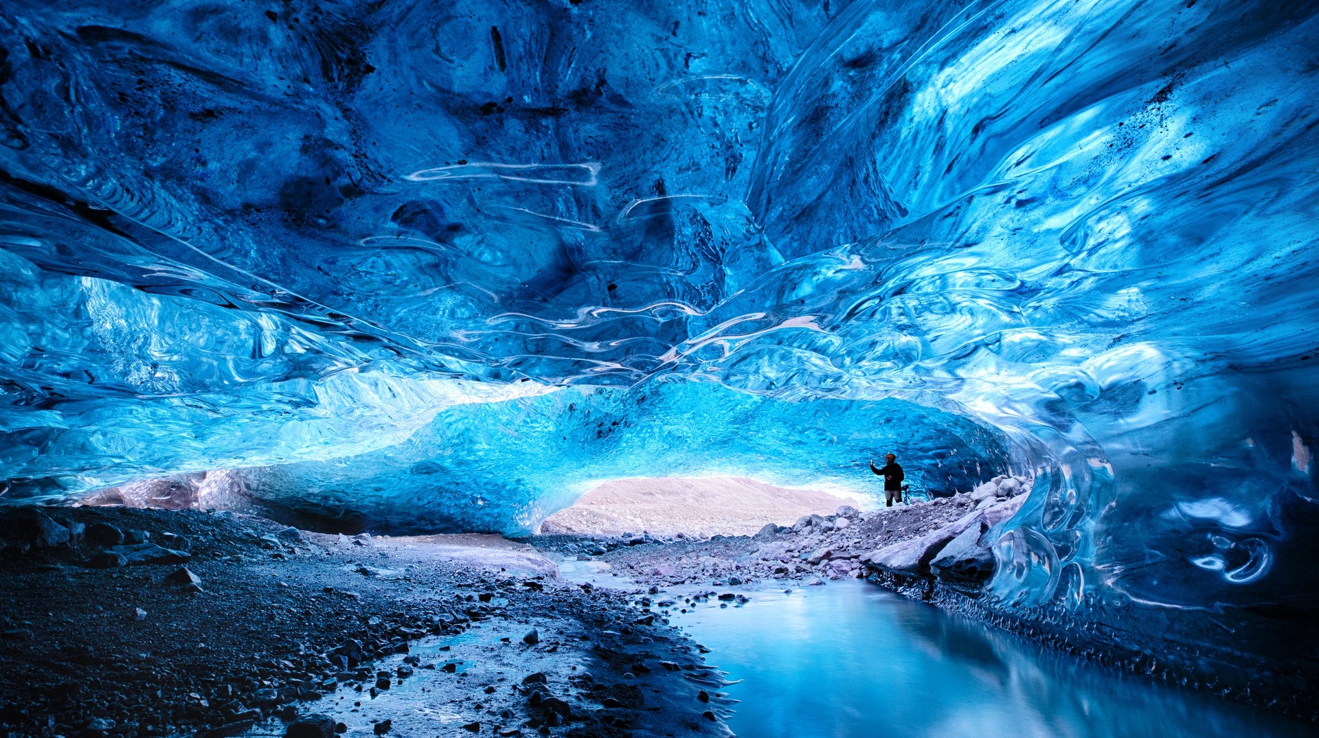 Man admiring an ice cave within Breioarmerkurjokull, Iceland, in November.