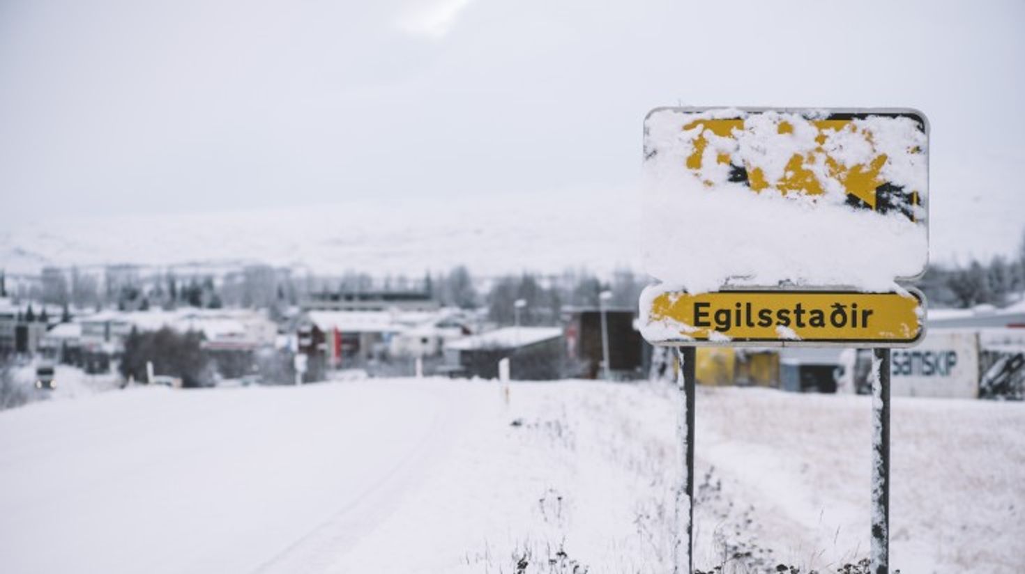 Egilsstadir road sign covered in snow during winter.