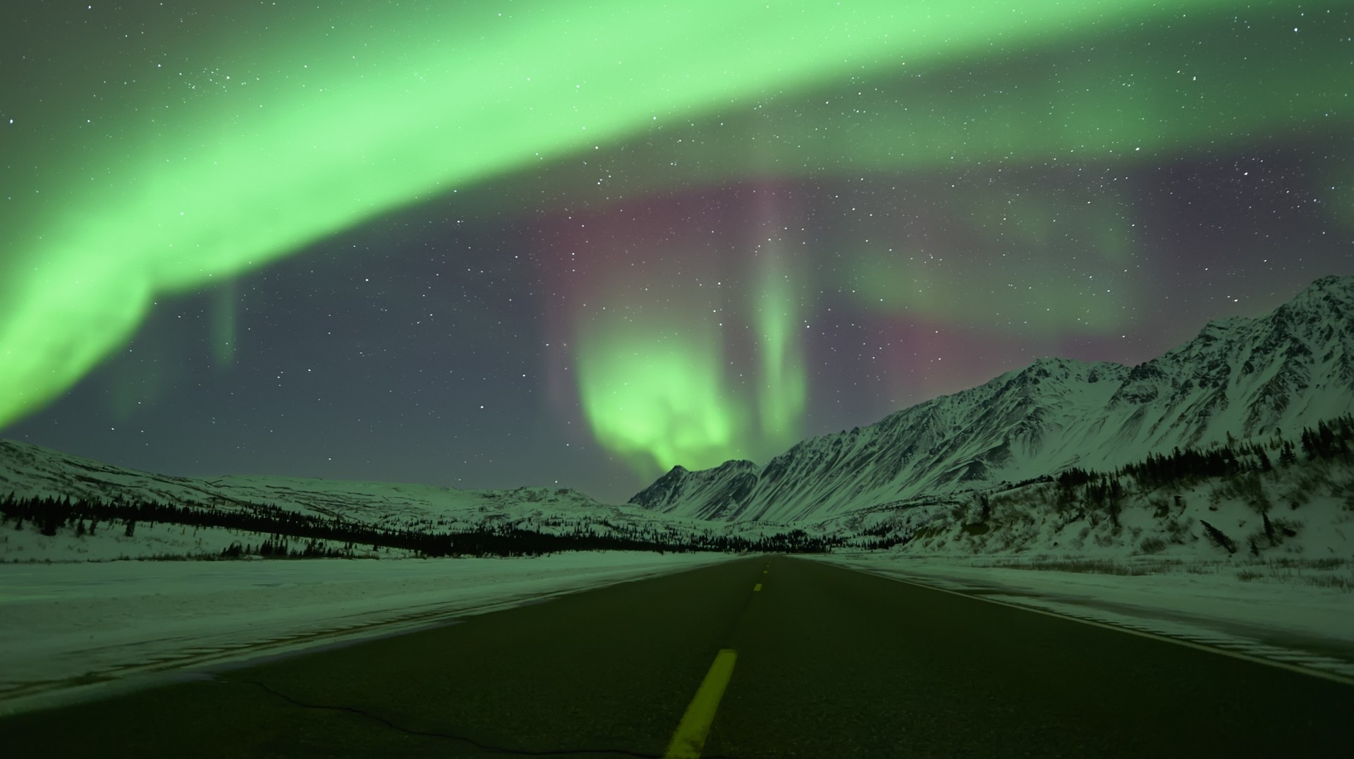 Take a road trip across Iceland to be rewarded with the spectacular views of the Northern lights in the dark. Northern Lights seen in the sky above Iceland’s Ring Road.
