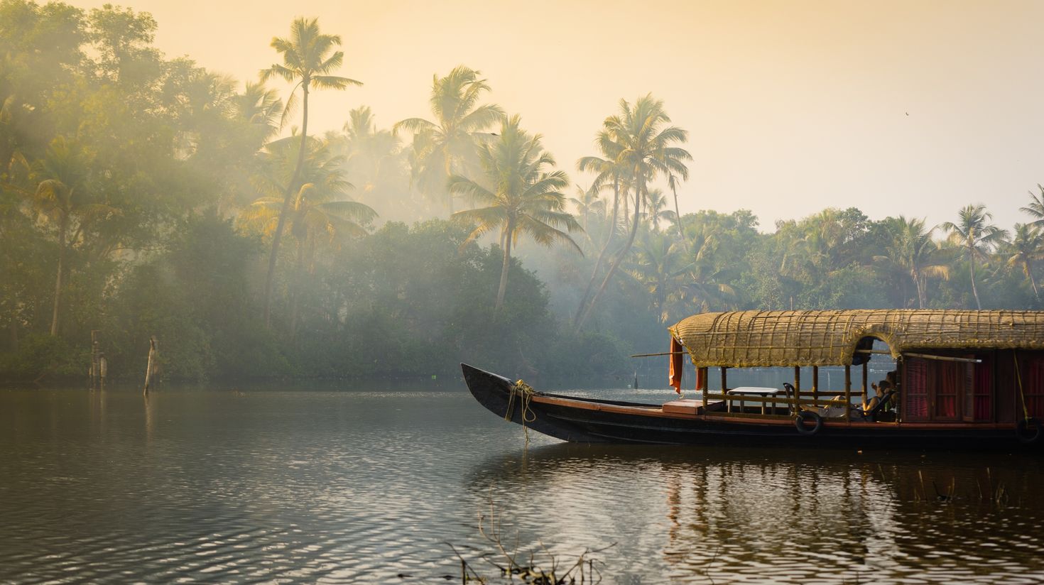 A traditional house boat is anchored on the shores of a fishing lake in Ker