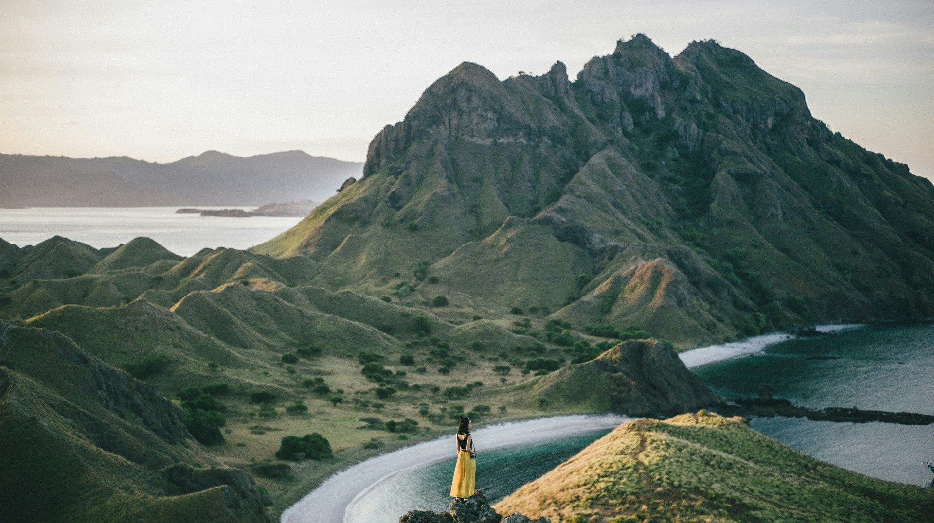 Famous for its unique landscapes, Padar Island located within the Komodo archipelago in Indonesia. A girl stands on a hill in Padar Island during 3 weeks in Indonesia