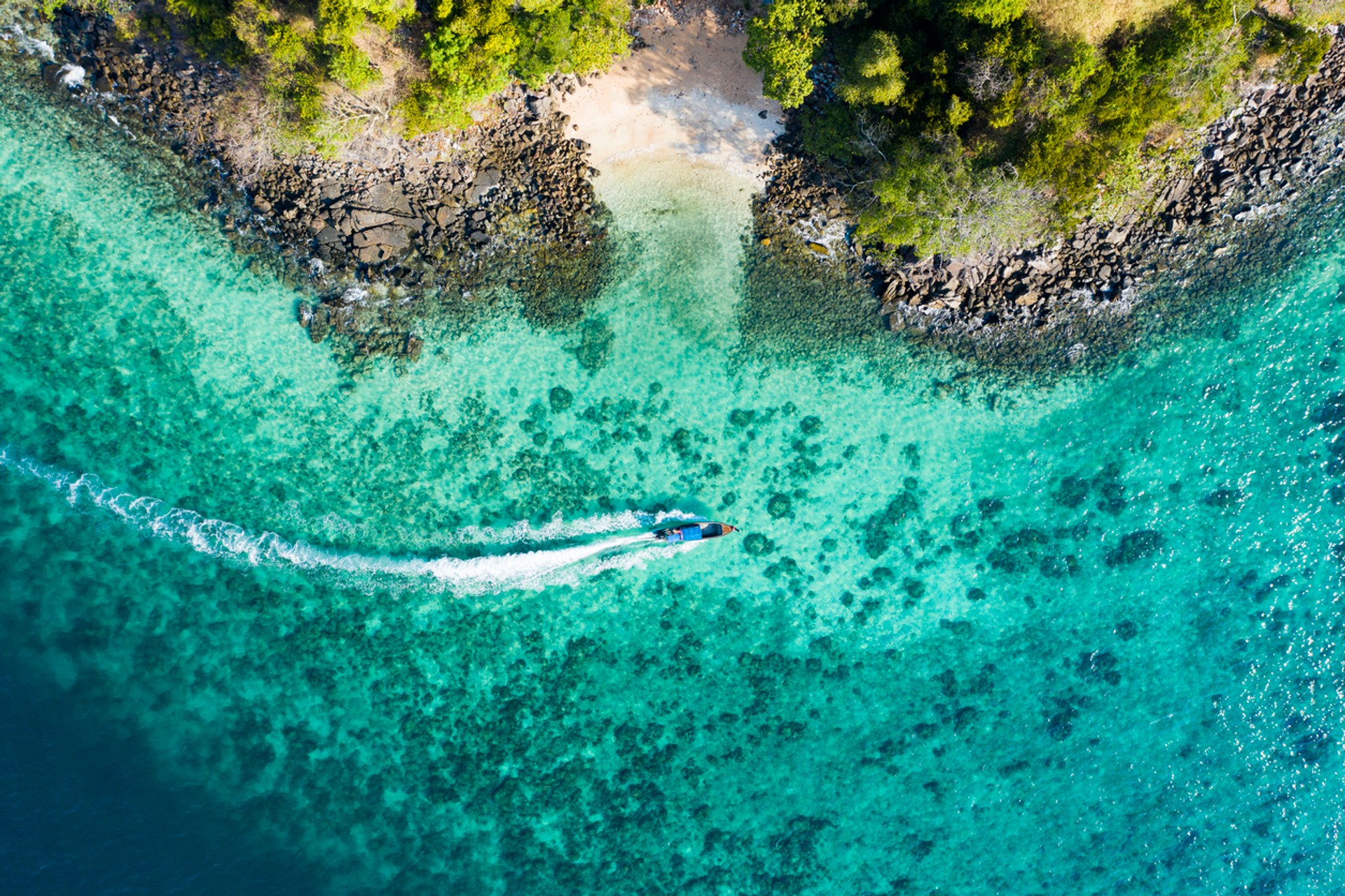 Experience the paradise in Phi Phi Islands as you go island hopping on your tour to Indonesia in August Bird's eye view of a long-tailed boat near Phi Phi Islands, Indonesia