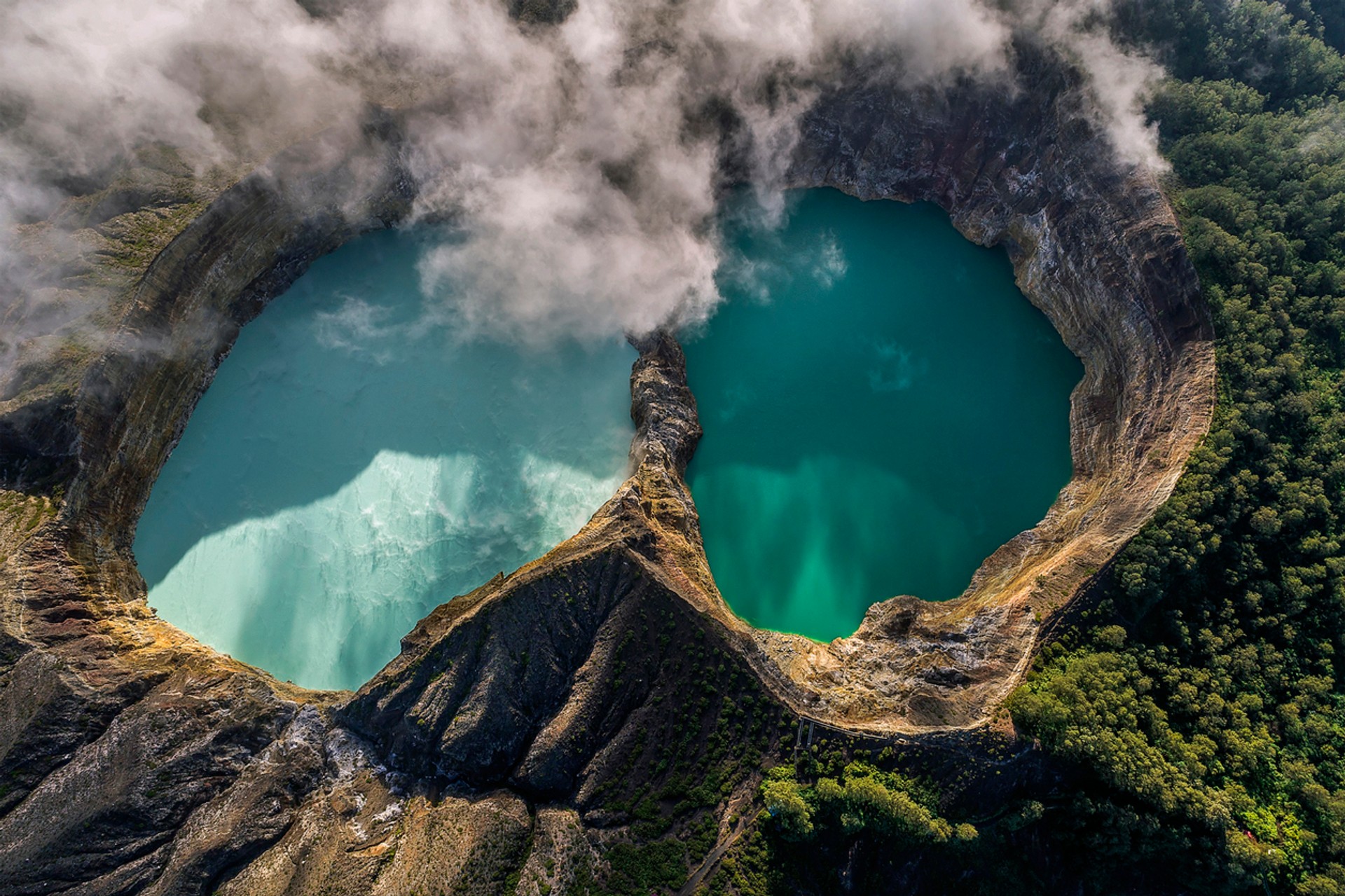 Did you know the landscape of Kelimutu volcano in Indonesia is guarded by a group of monkeys? Aerial view of Kelimutu volcano and its crater lake, Flores, Indonesia