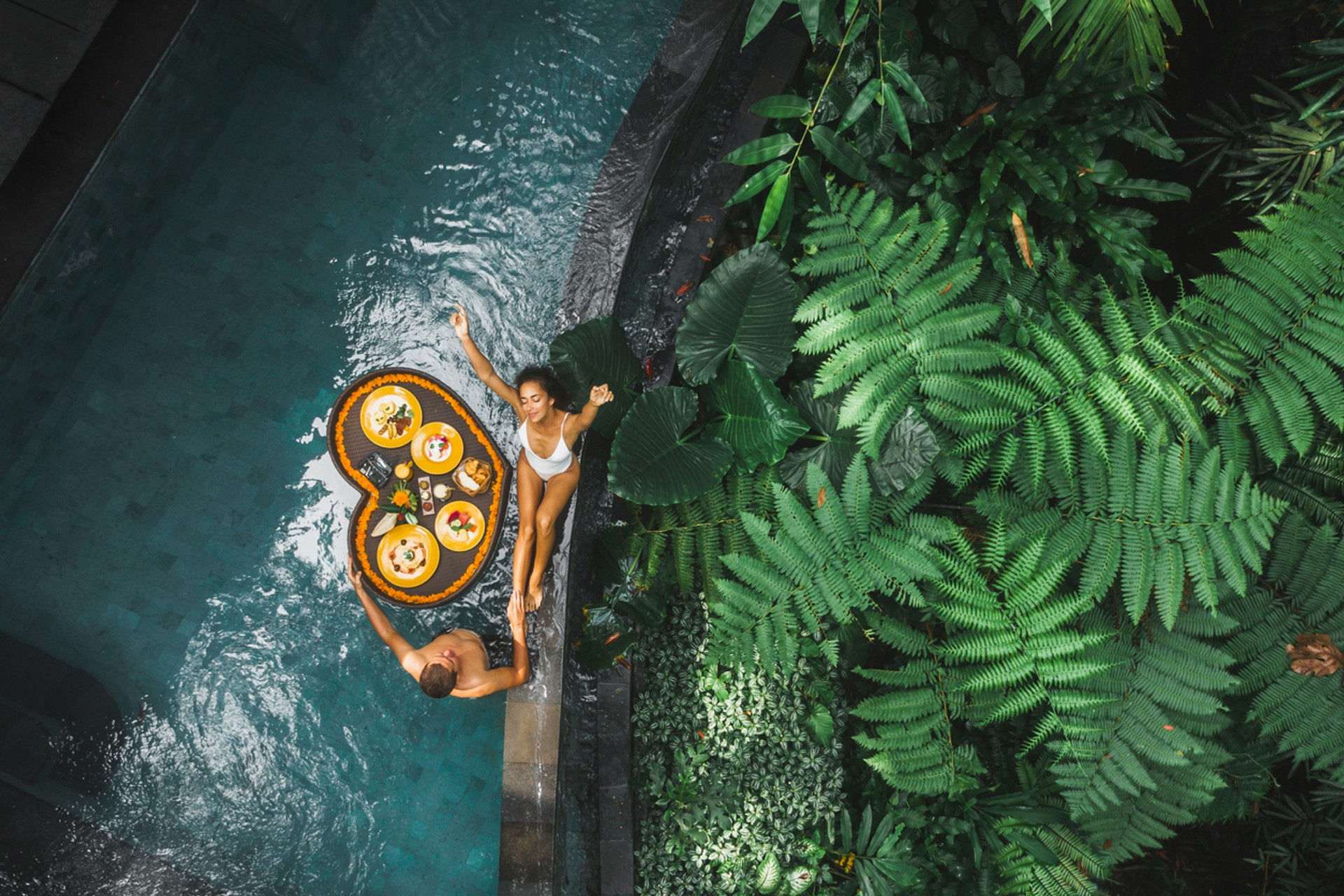A couple having breakfast near a pool in a Bali resort in Indonesia in September