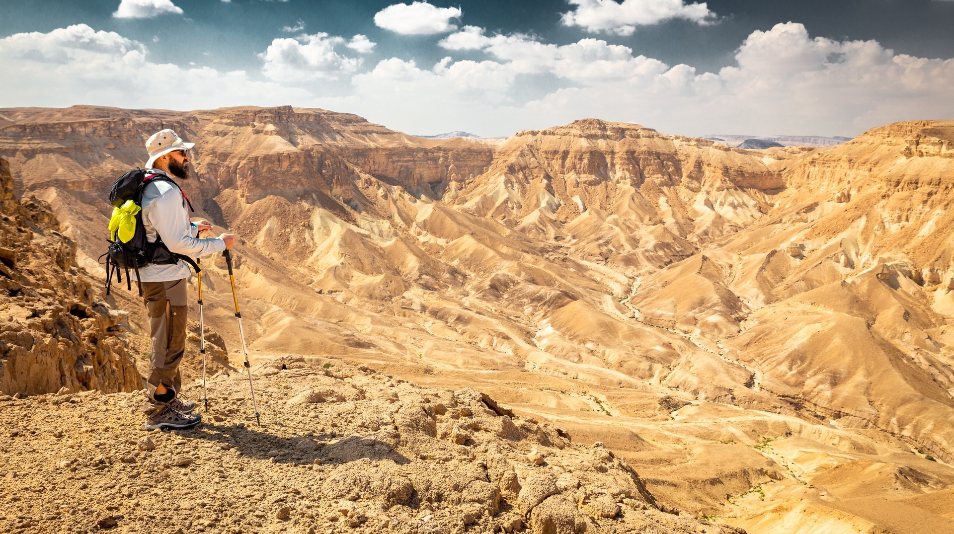 Embark on a memorable hike in Israel in September. A young hiker on mountain ridge cliff edge in Israel in September.