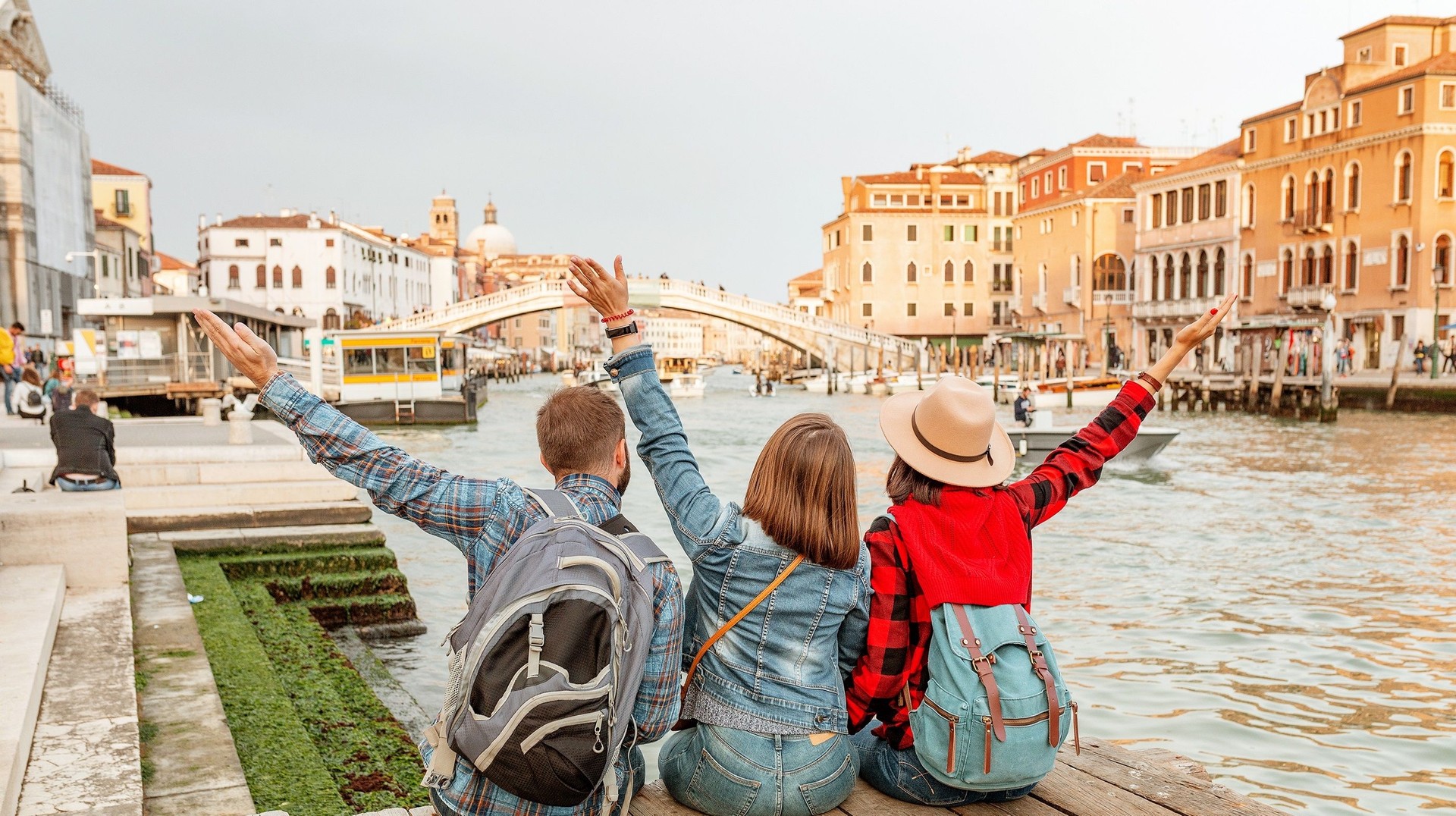 A group of friends posing in front of Venice canal during their 6 days in Italy.