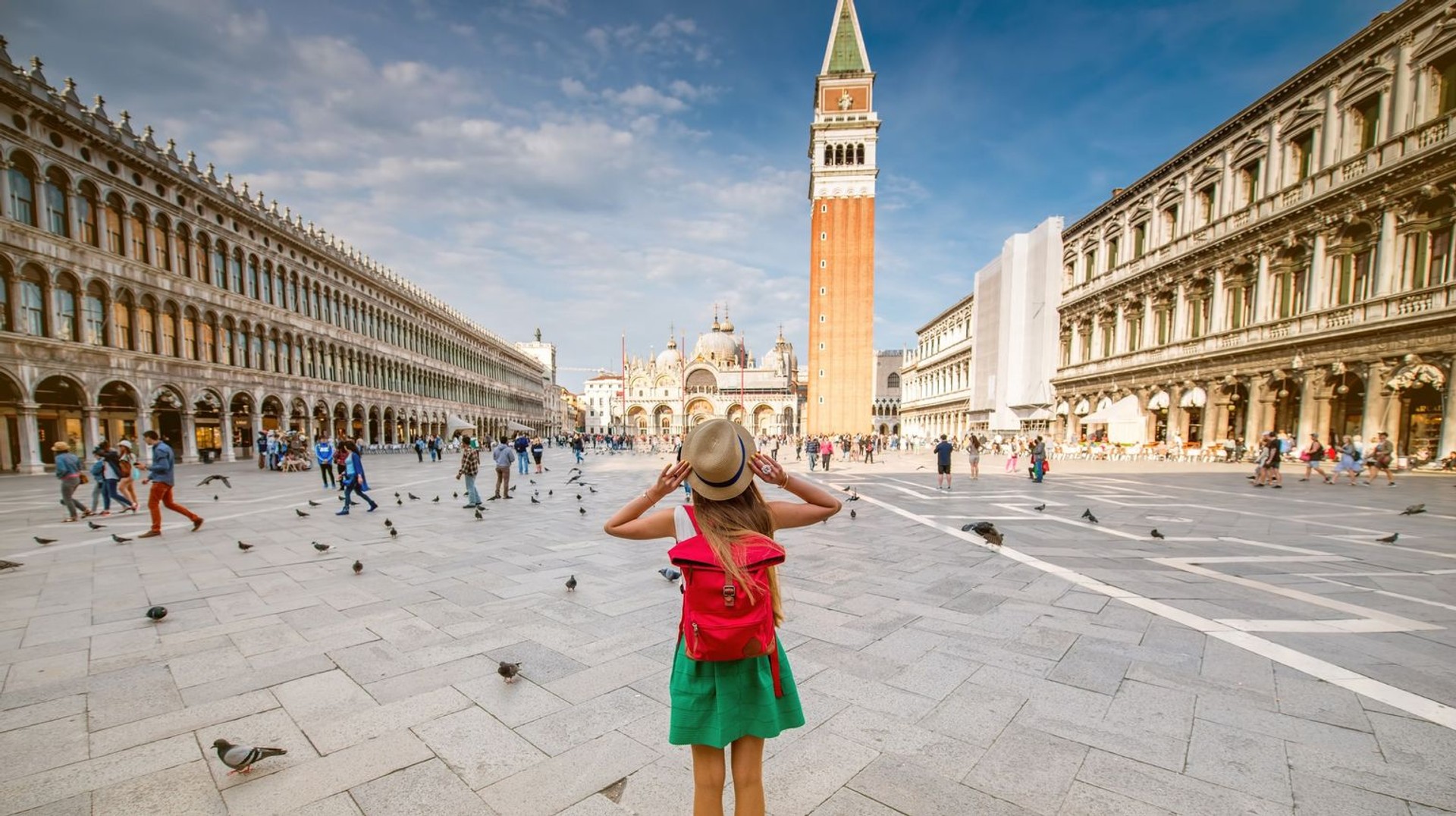 Young female traveler standing on San Marco Square with tower during her 9 days in Italy.