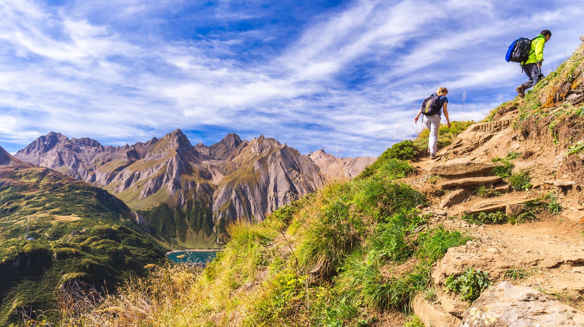 Explore the hiking trails in the mountains in Piedmont, Italy in April. A young couple hiking in the mountains on a sunny day in Piedmont, Italy in April.
