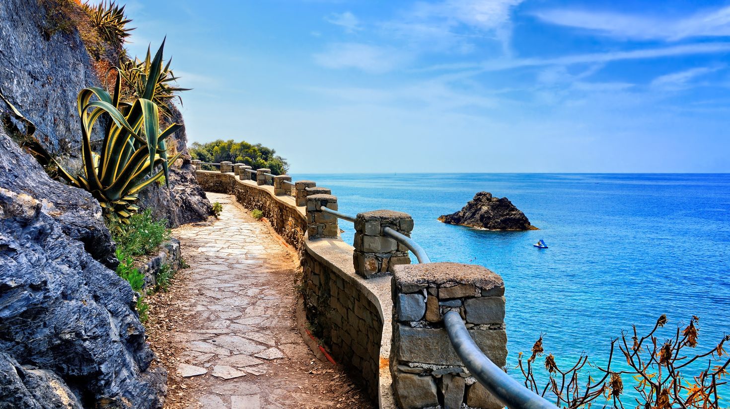 A stone hiking path along the brilliant blue sea in Cinque Terre, Italy.