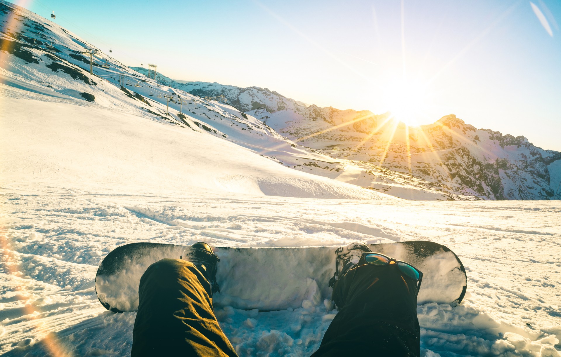 Snowboarder sitting and enjoying the sunset in Italy in January.
