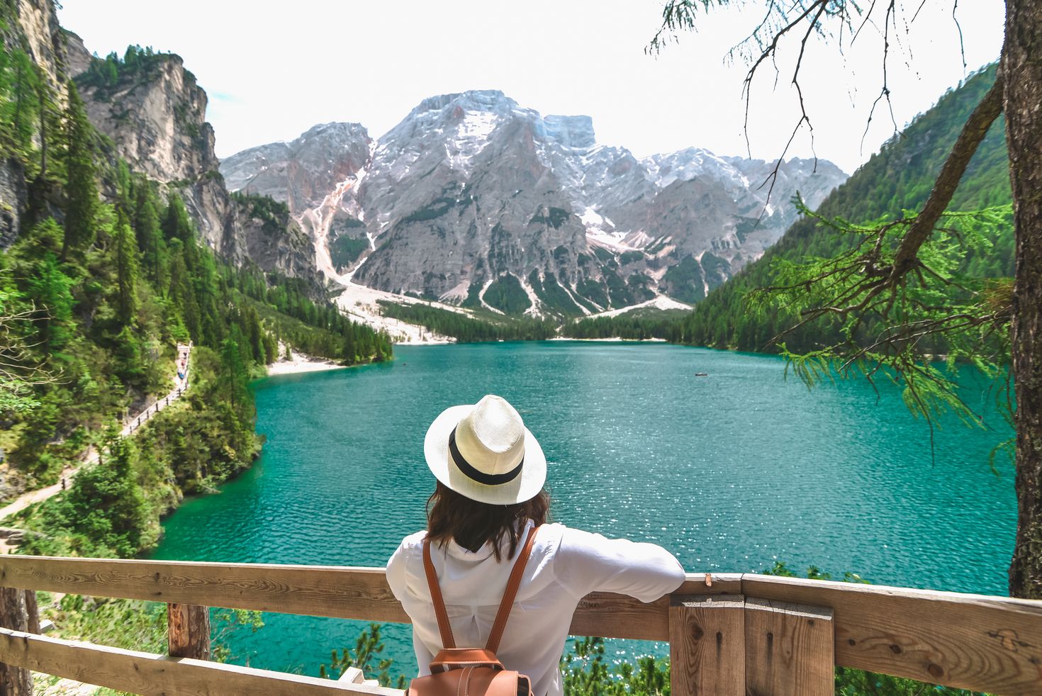 A traveler overlooking a lake in Dolomites alps